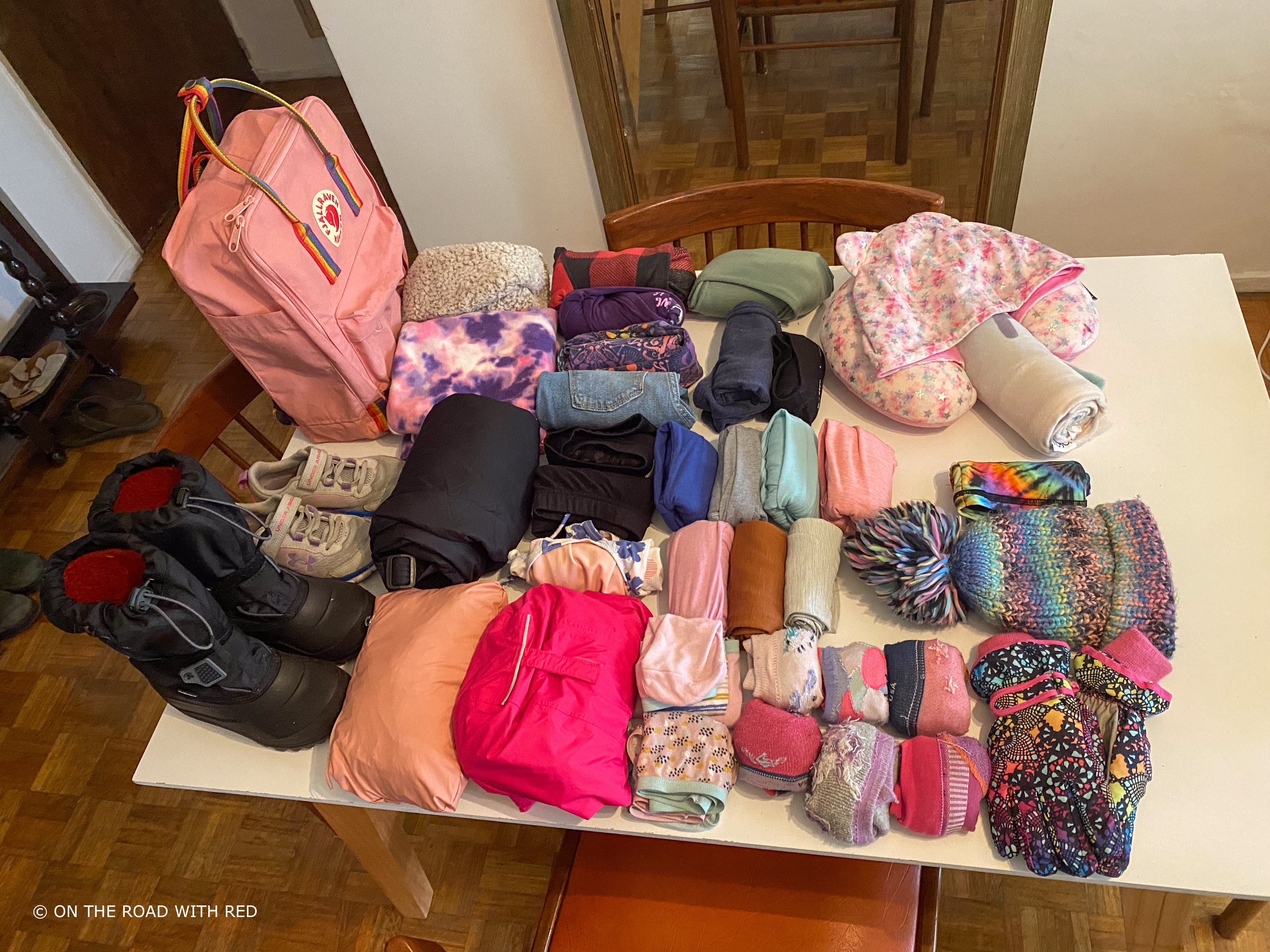 a table with a childs clothes ready to be packed