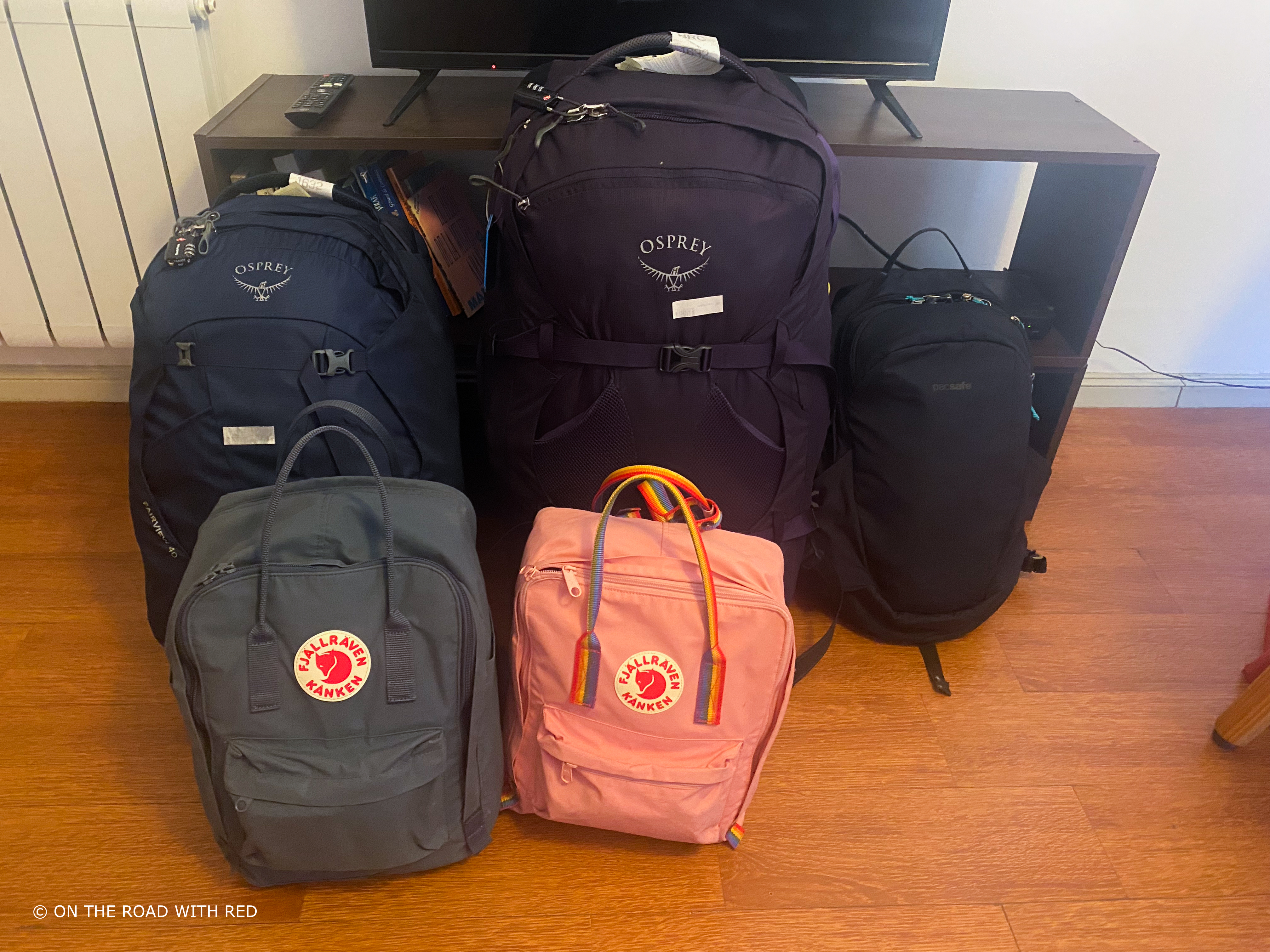 5 full backpacks sitting on a floor