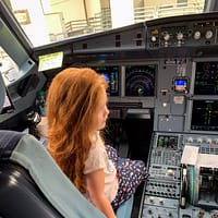 kaia sitting in the captains seat of an airplaine
