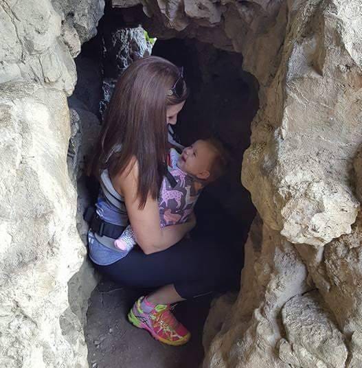 mom holding a baby in a cave