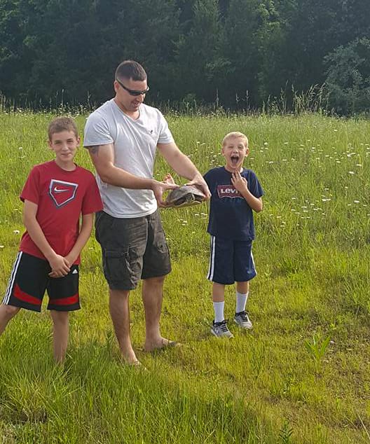 2 boys with a man holding a snapping turtle