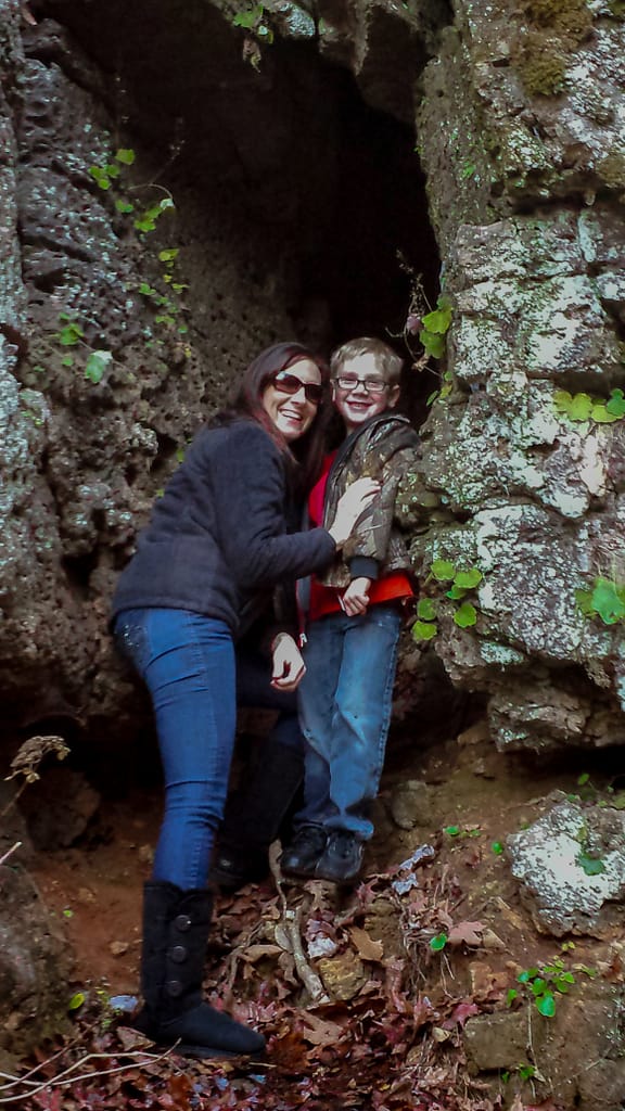 a woman and boy standing in a cave.