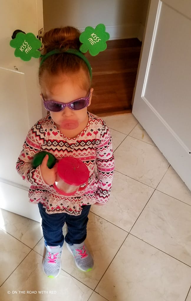 a redhead with green st. patricks day headband and toy coffee pot