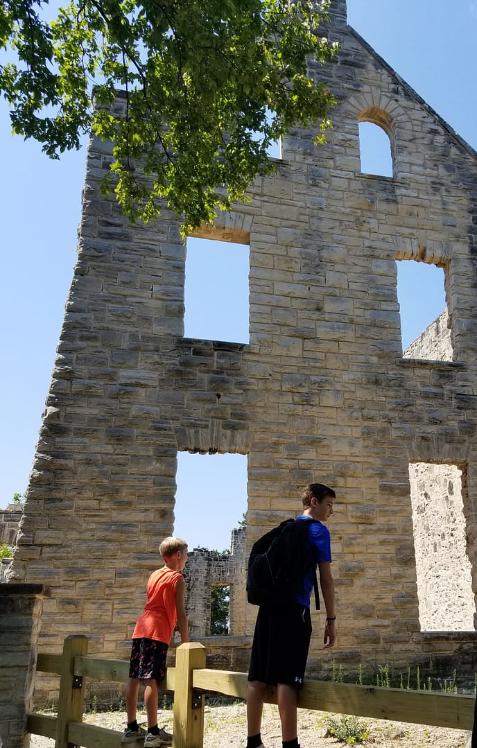 two boys in front of historic ruins