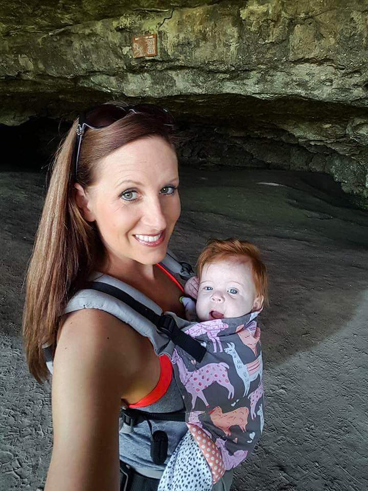 a woman holding a baby in a cave