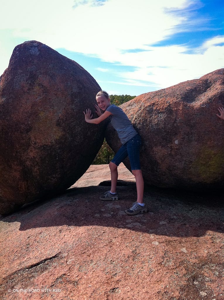 a girl holding up a boulder