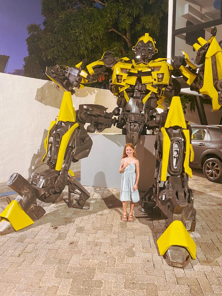 a child in front of a large bumble bee statue