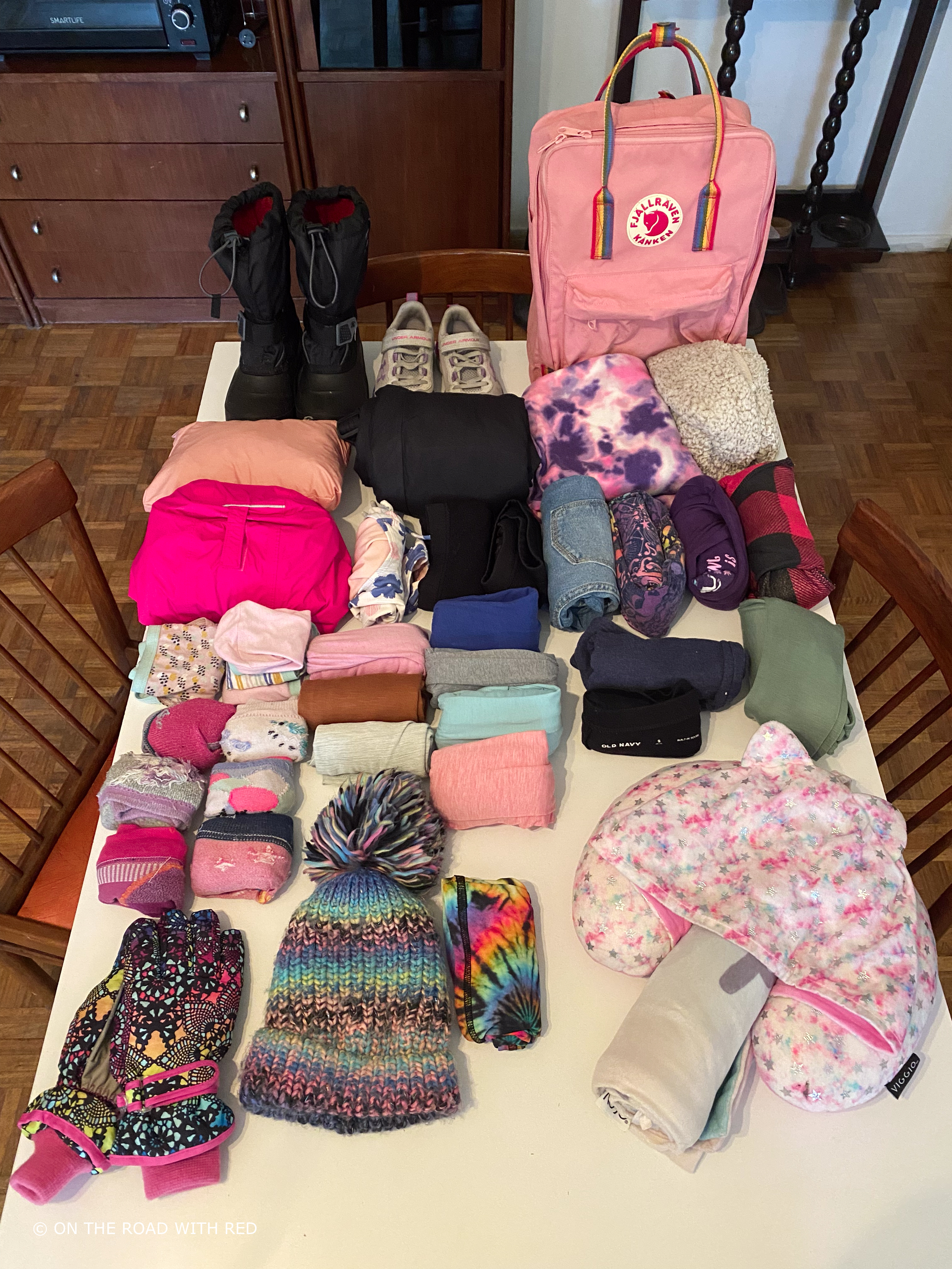 a table with a childs clothes ready to be packed