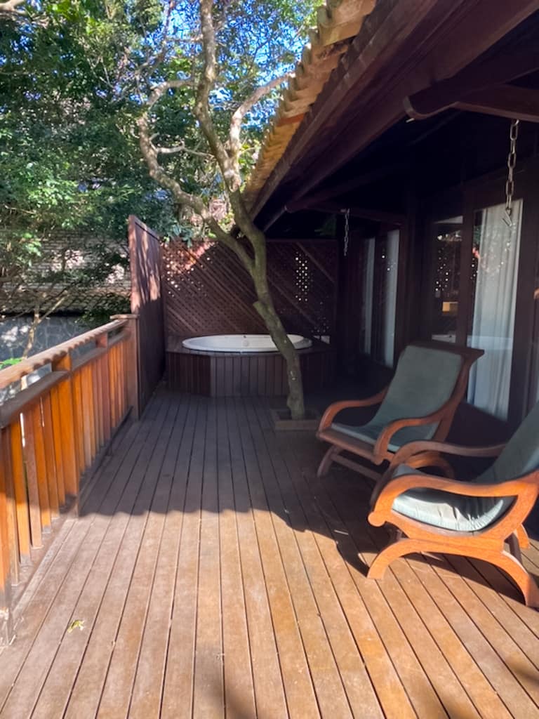 a hot tub and two chairs on a deck