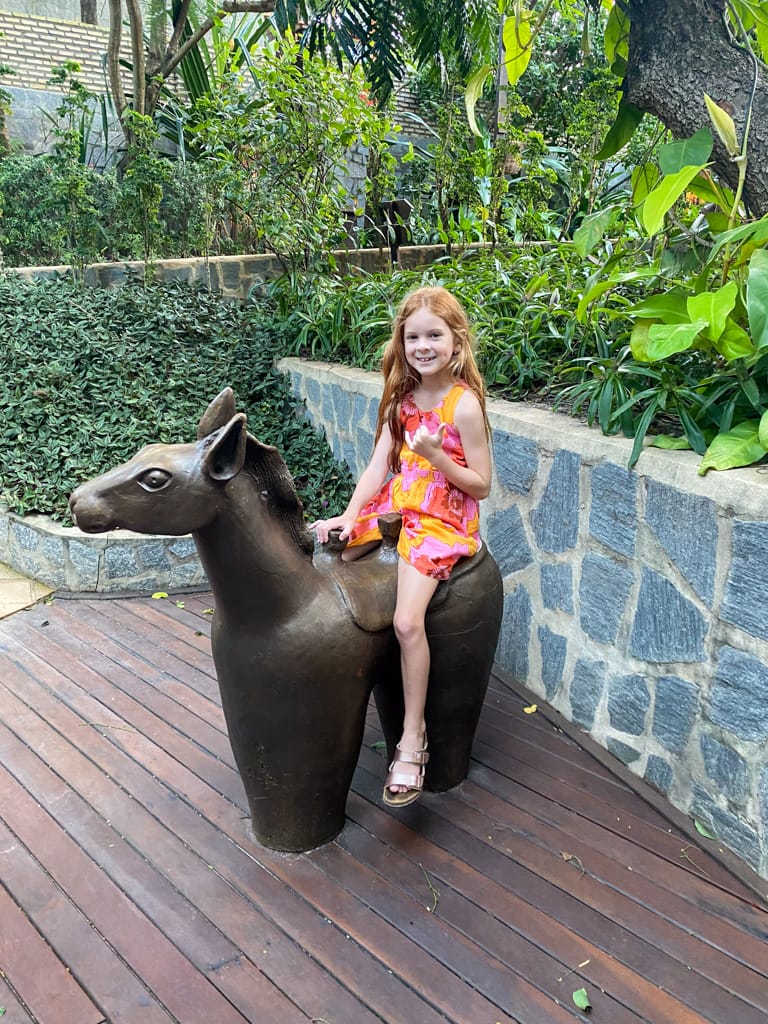 a child sitting on a horse statue