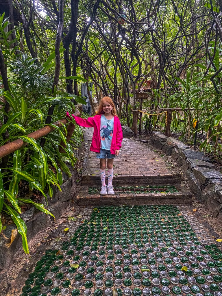 a girl standing on path in the jungle