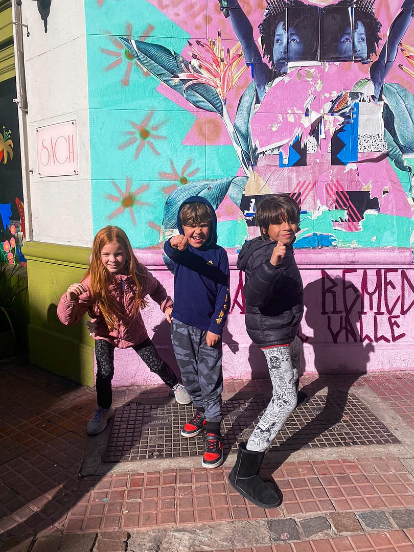 three children in front of a mural at san telmo market
