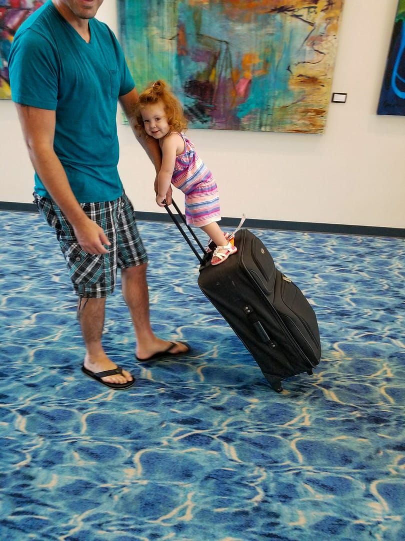 a child riding on luggage