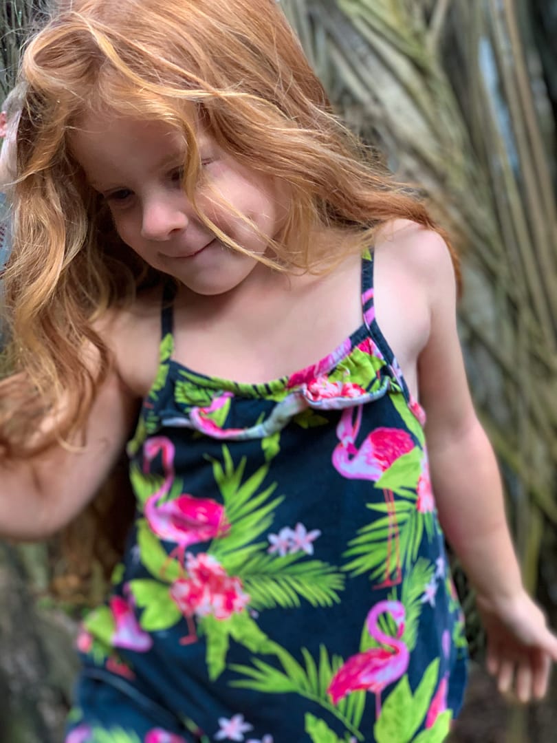 child walking between banyan trees