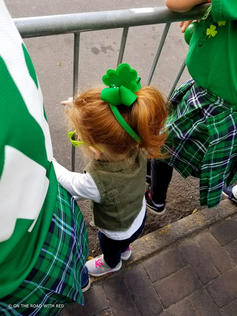 a redheaded toddler watching a st. patricks day parade