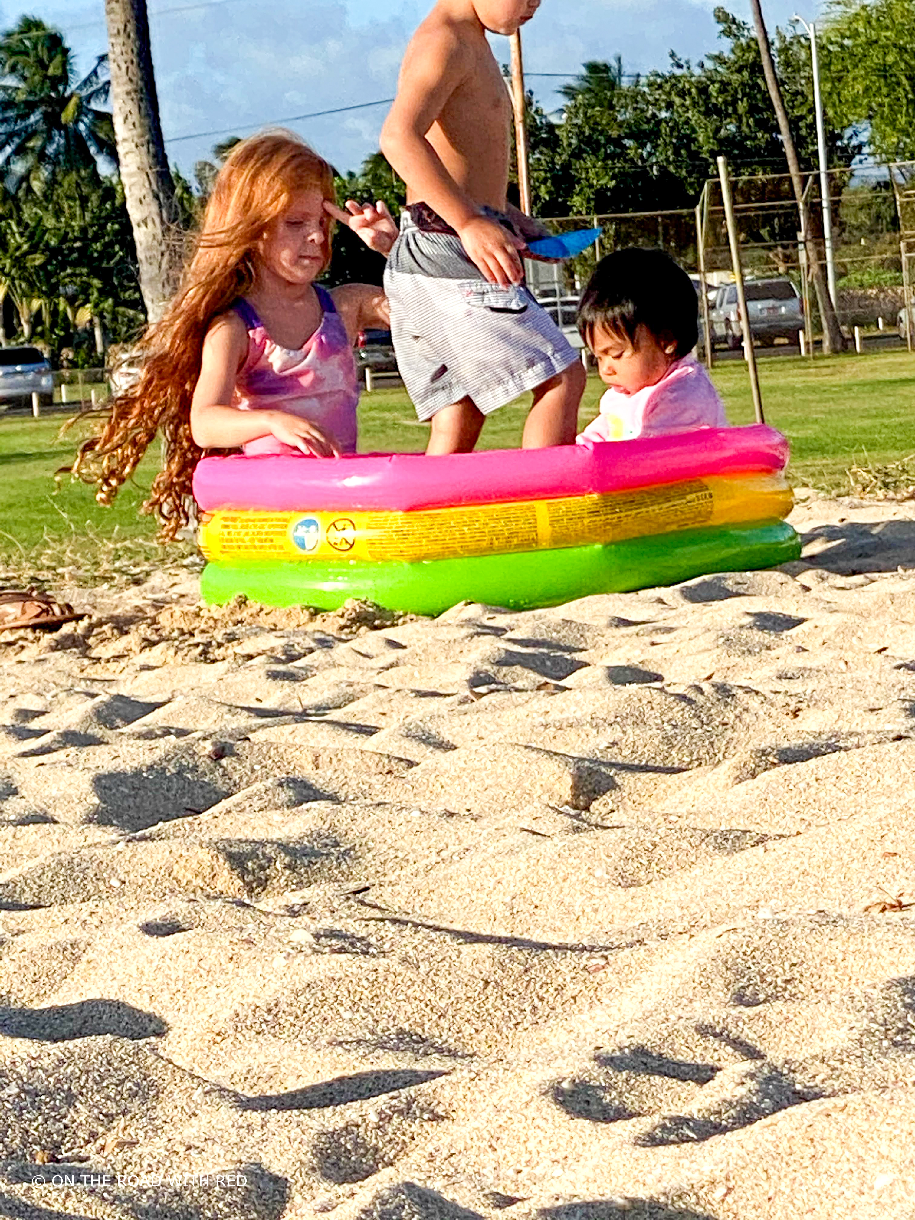 kids playing in a baby pool on the beach