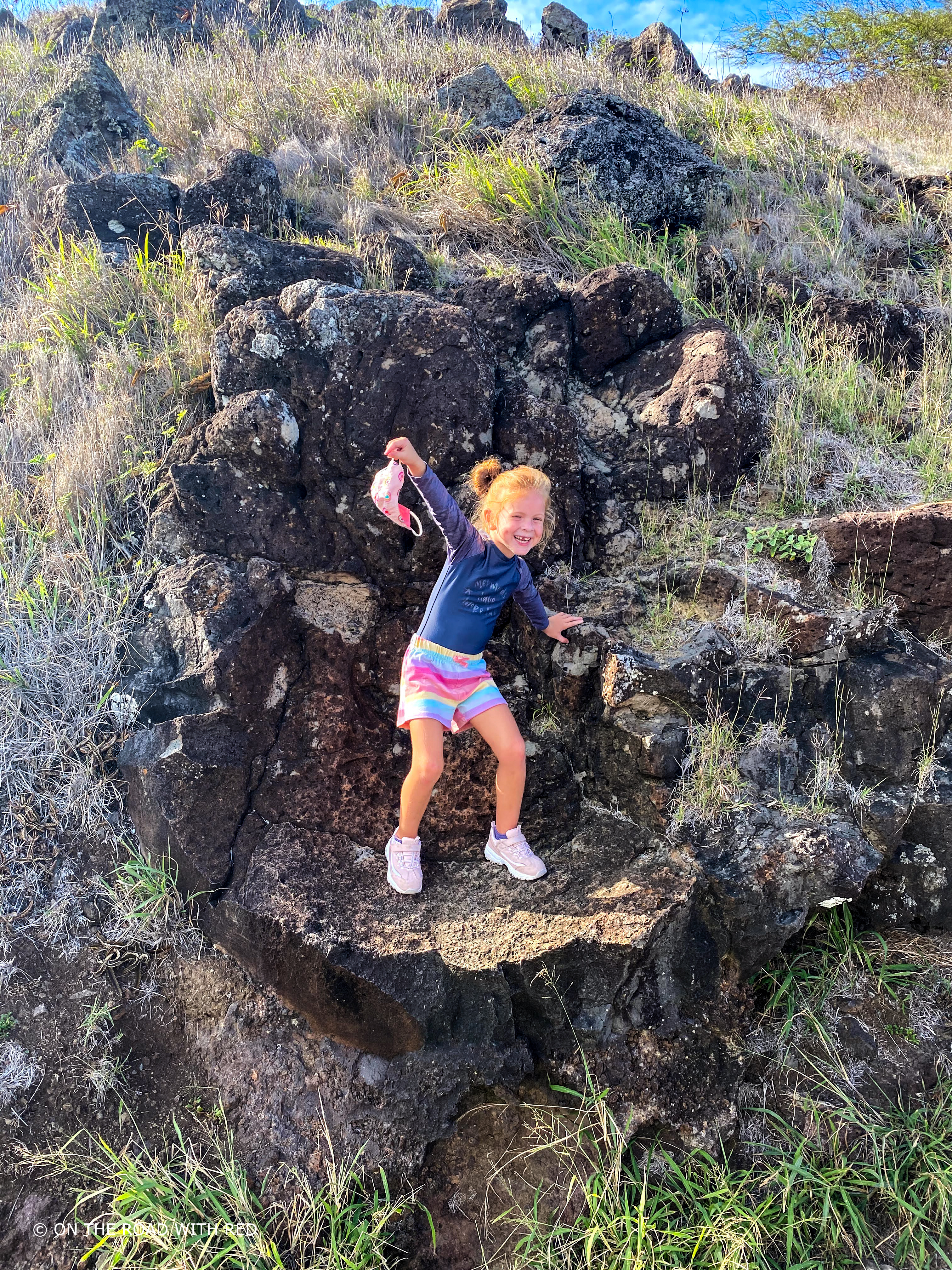 a young girl standing on a rock