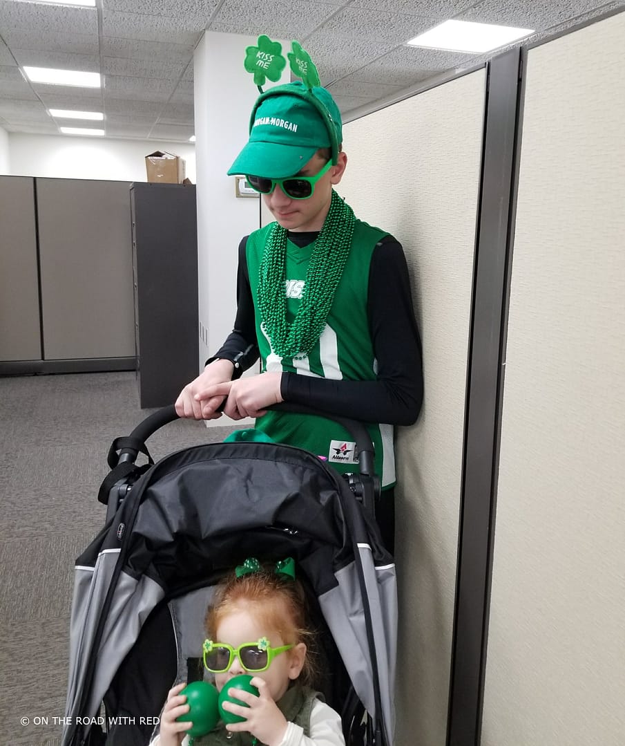 a teenager with a toddler in a stroller in st. patricks day clothing