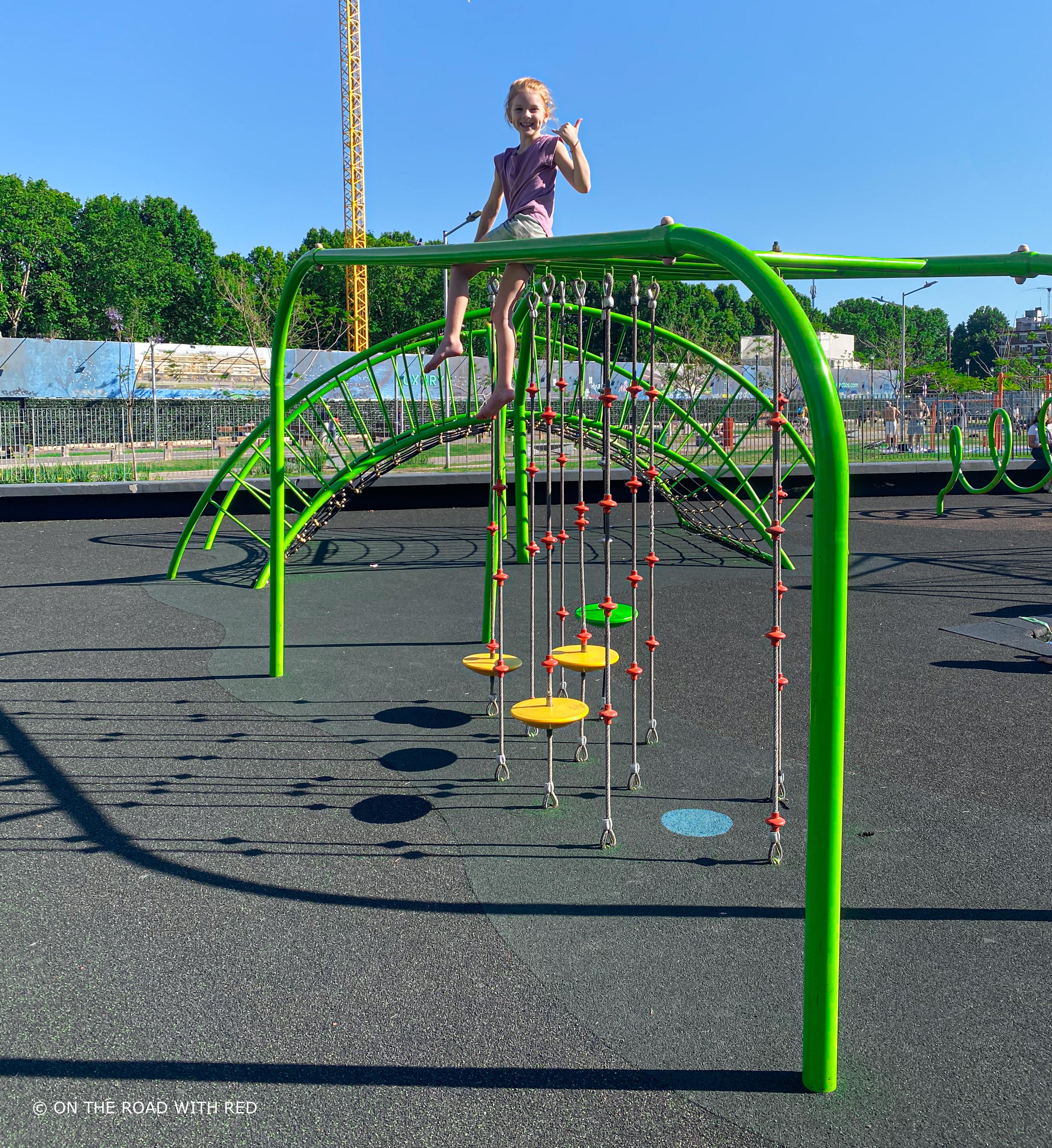 a girl on top of a jungle gym at a park