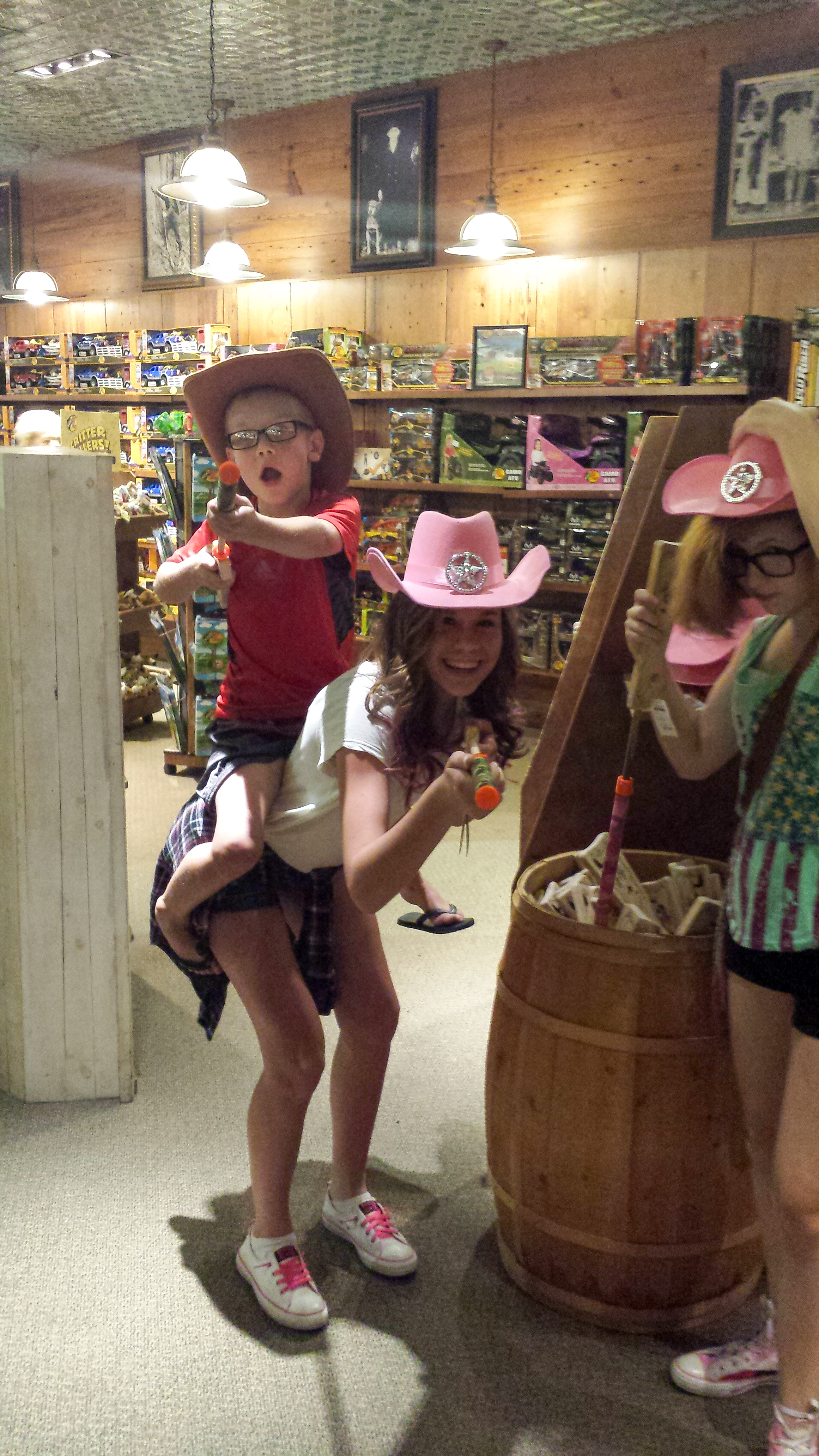 a child sitting a girls back with toy guns.