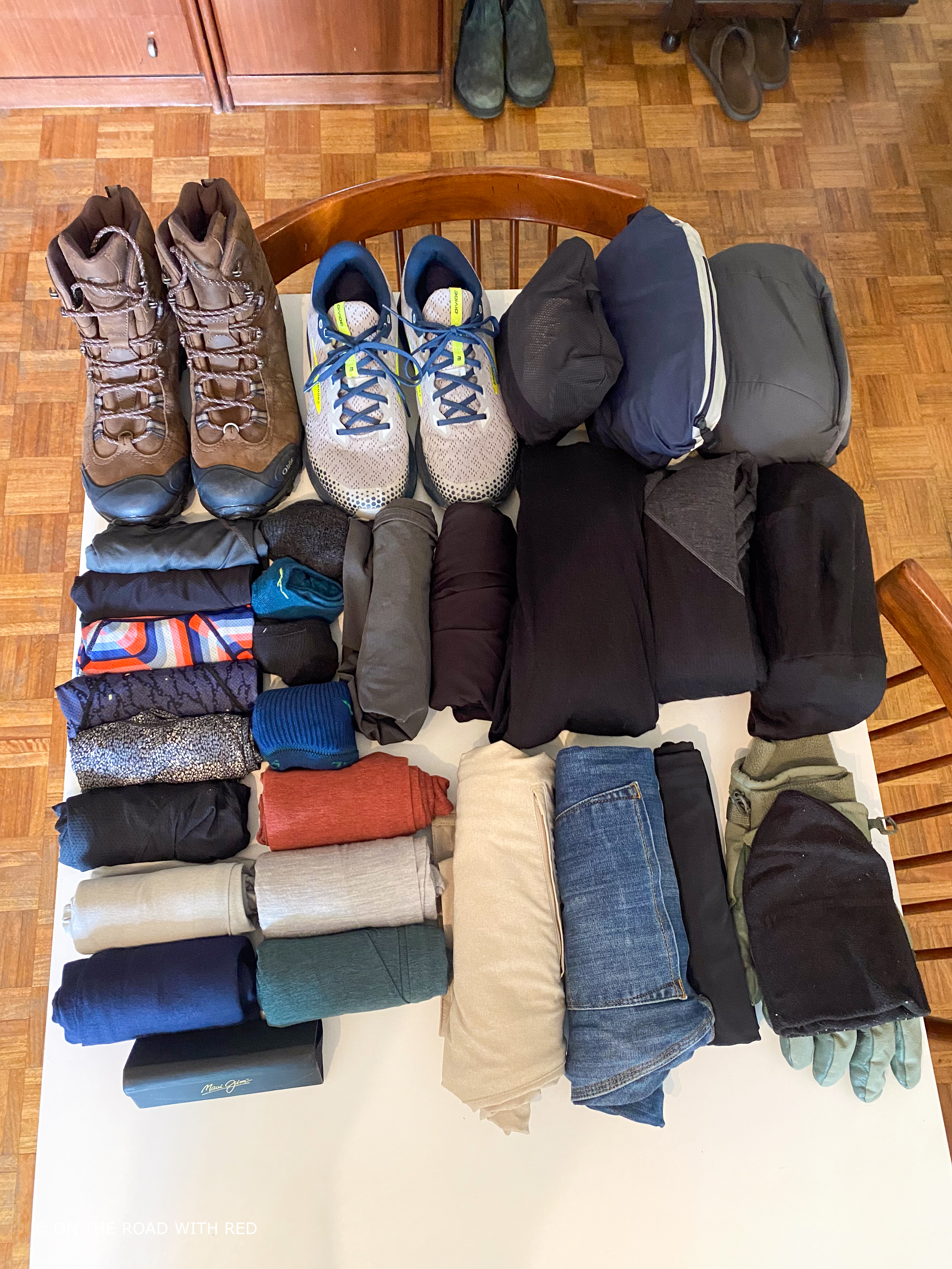 a table with a mans clothes ready to be packed